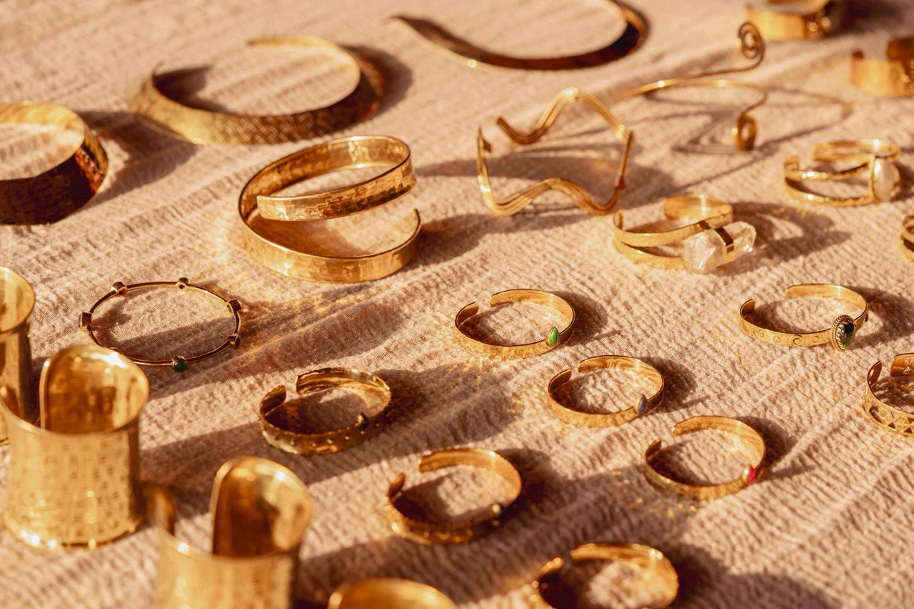 Collection of gold jewelry on a textured surface