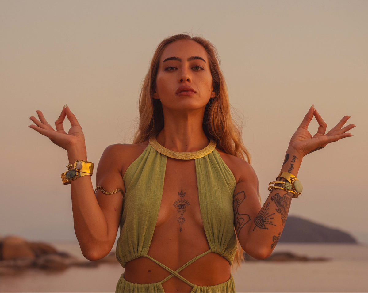 Temple of Sundara lookbook — model on the beach wearing Land of Sundara brass jewelry, ocean horizon in the background